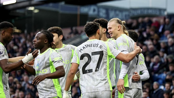 Soccer players celebrate a goal, embracing on the pitch; Matheus N. #27 is visible on a jersey.