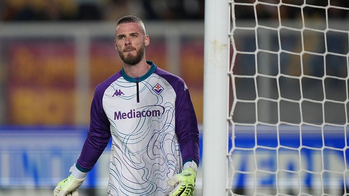 Fiorentina goalkeeper standing by the goal in a white and purple kit with Mediacom sponsor.