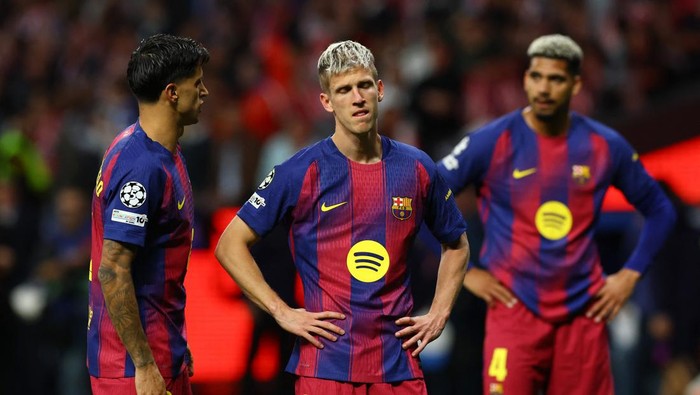Three FC Barcelona players stand on the field during a match, wearing blue and maroon striped jerseys with a yellow logo on the chest.