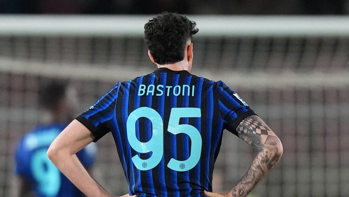 Soccer player seen from behind wearing a blue-and-black striped jersey with the number 95 and the name Bastoni.