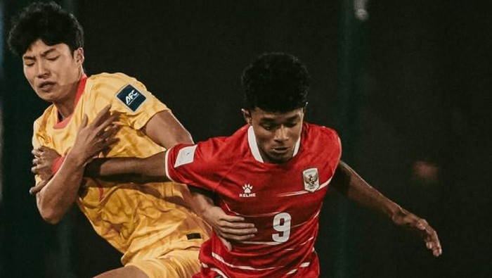 Two soccer players in action battling for the ball: one in yellow on the left, the other in red with number 9 on the shirt on the right.