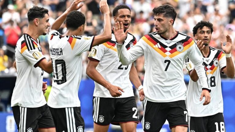 German men's national soccer team players celebrate with high-fives on the field after a goal