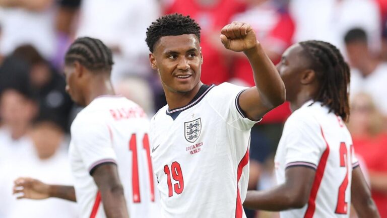 England national football team player in white jersey number 19 raises his fist in celebration on the field, with teammates nearby