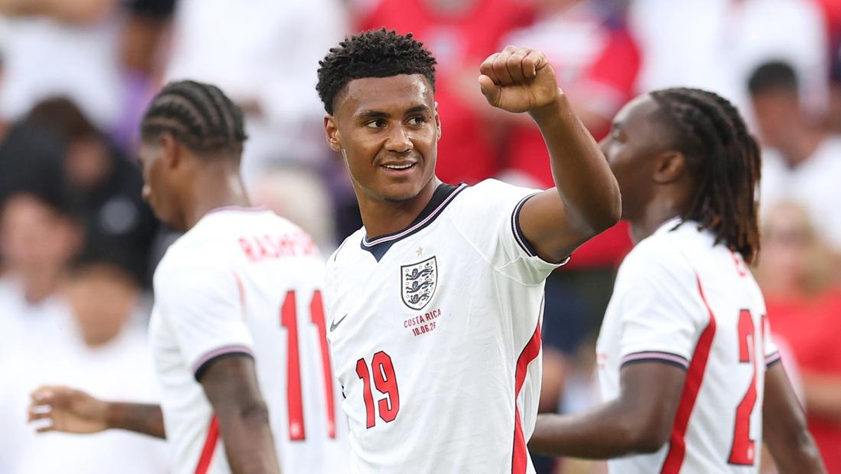 England national football team player in white jersey number 19 raises his fist in celebration on the field, with teammates nearby