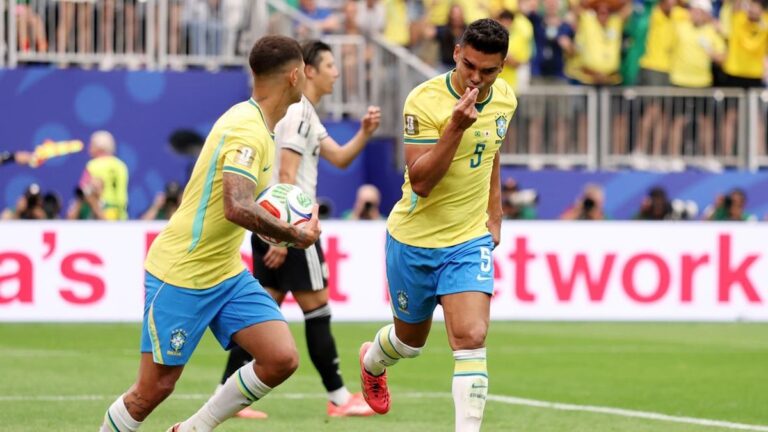 Brazilian soccer players in yellow jerseys celebrate on the field during a match.