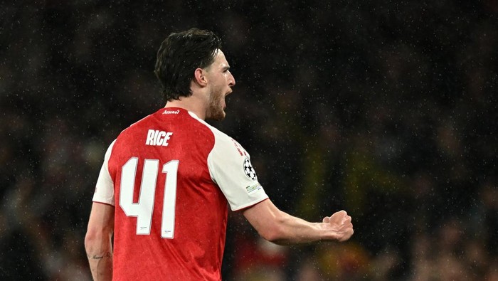 Soccer player with jersey number 41 and name Rice celebrates on the field in the rain.