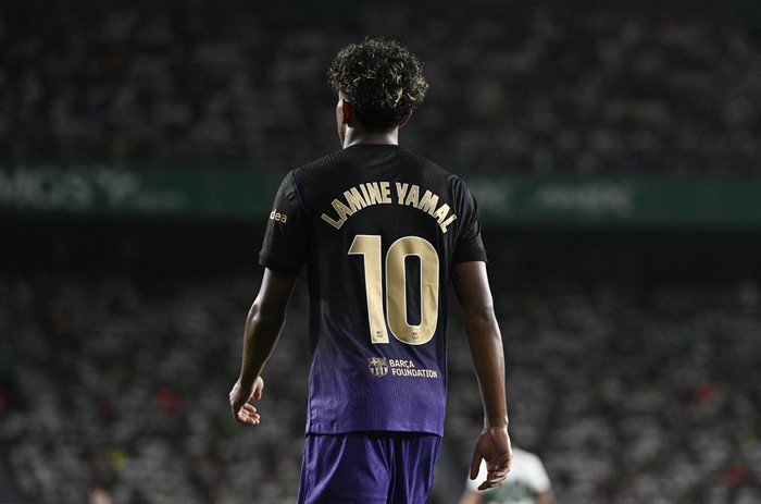 Soccer player seen from behind wearing a black-to-purple gradient jersey with the name Lamine Yamal and number 10.