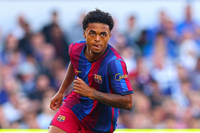 Soccer player in blue and red Barça jersey sprinting on the field during a match.