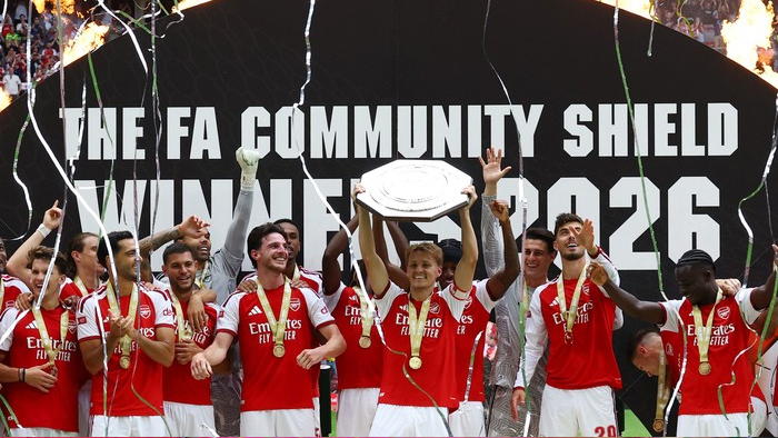 Arsenal players celebrate after winning the FA Community Shield 2016, holding the trophy amid confetti.