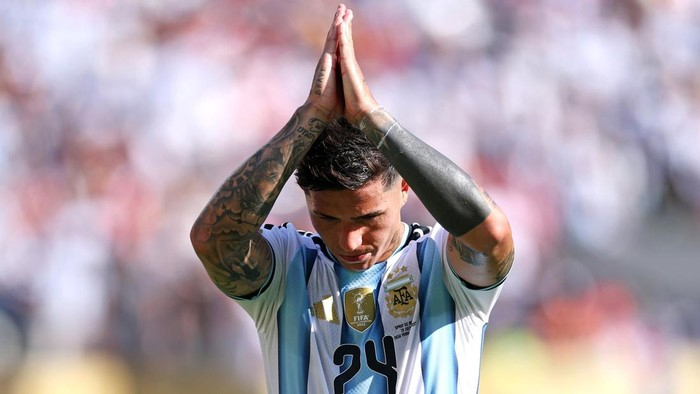 Soccer player in a light blue and white jersey with number 24, hands pressed together in prayer on the field.