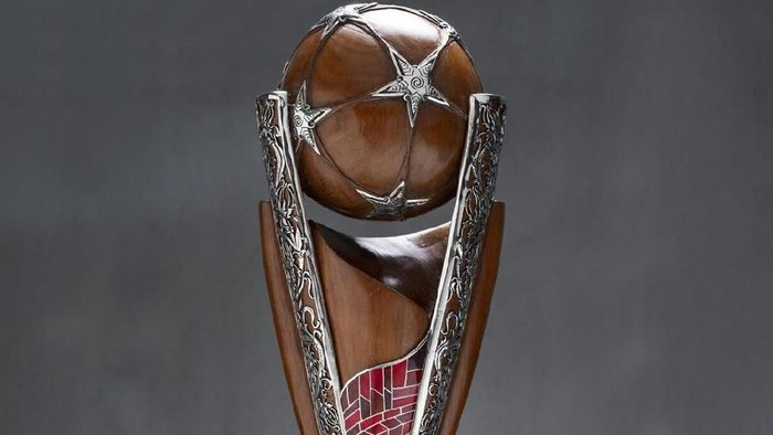 Trophy with a wooden base and ornate silver blades surrounding a brown spherical top.